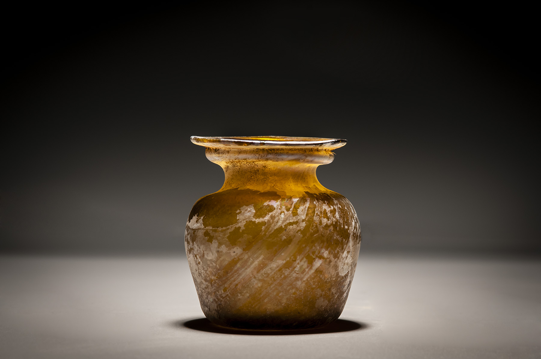 A Roman Amber Glass Jar with Diagonal Ribbing